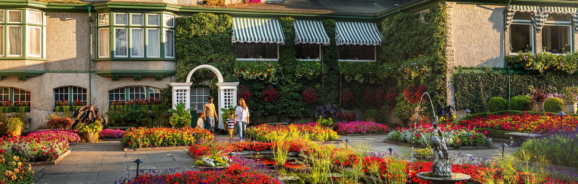A young family walks through the Italian Garden at The Butchart Gardens in Victoria, BC